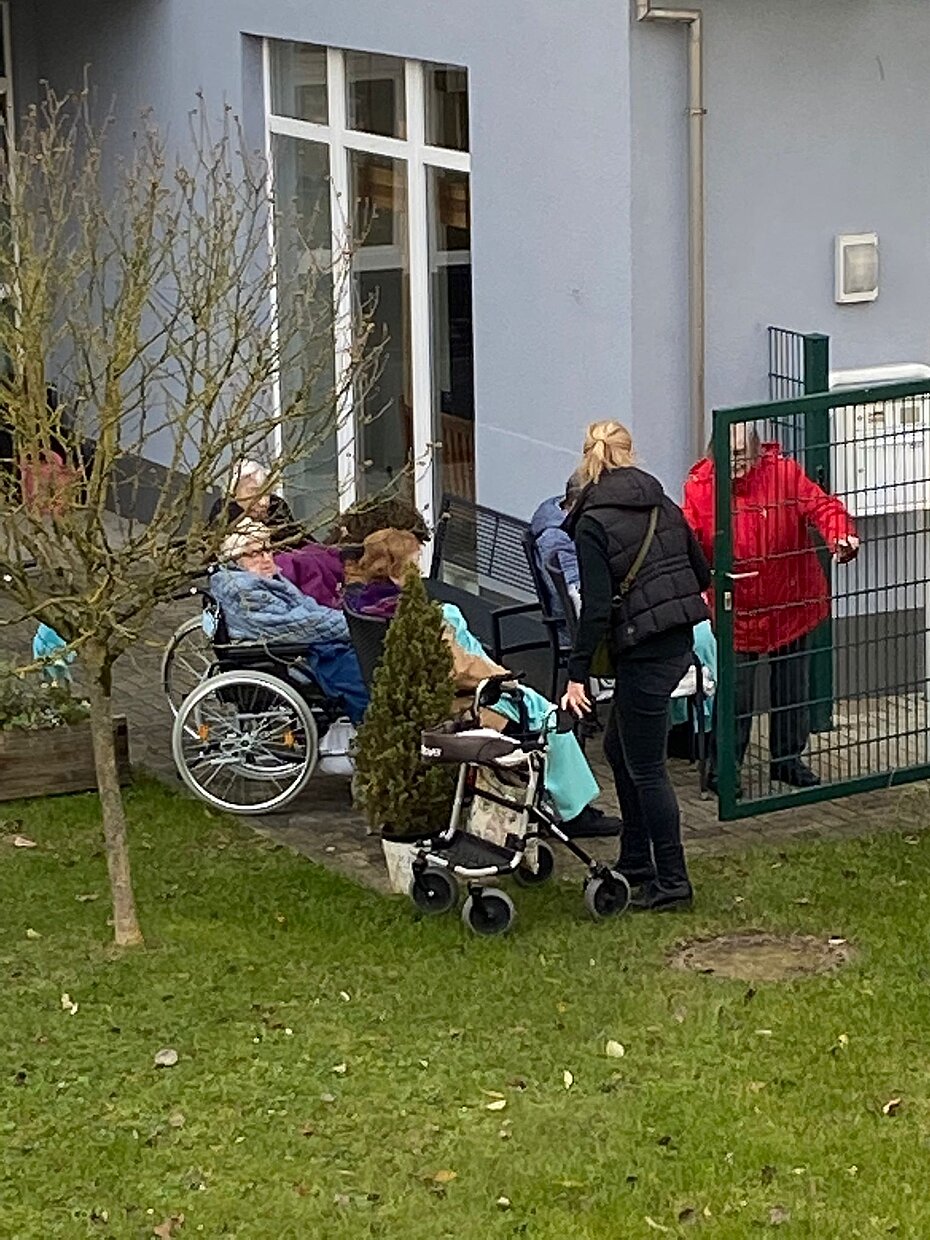 Zuhörer sitzen draußen mit Decke