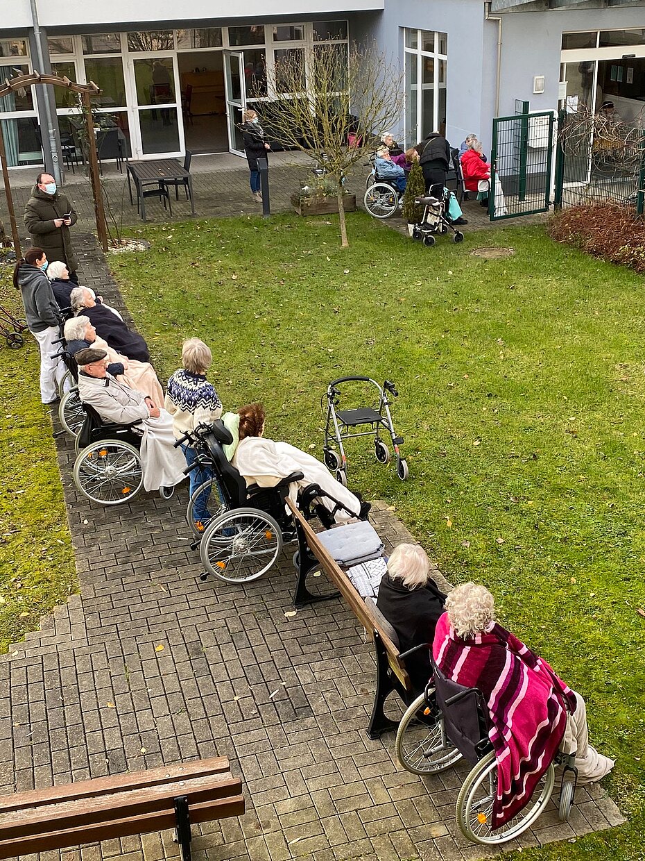 Zuhörer sitzen draußen mit Decke