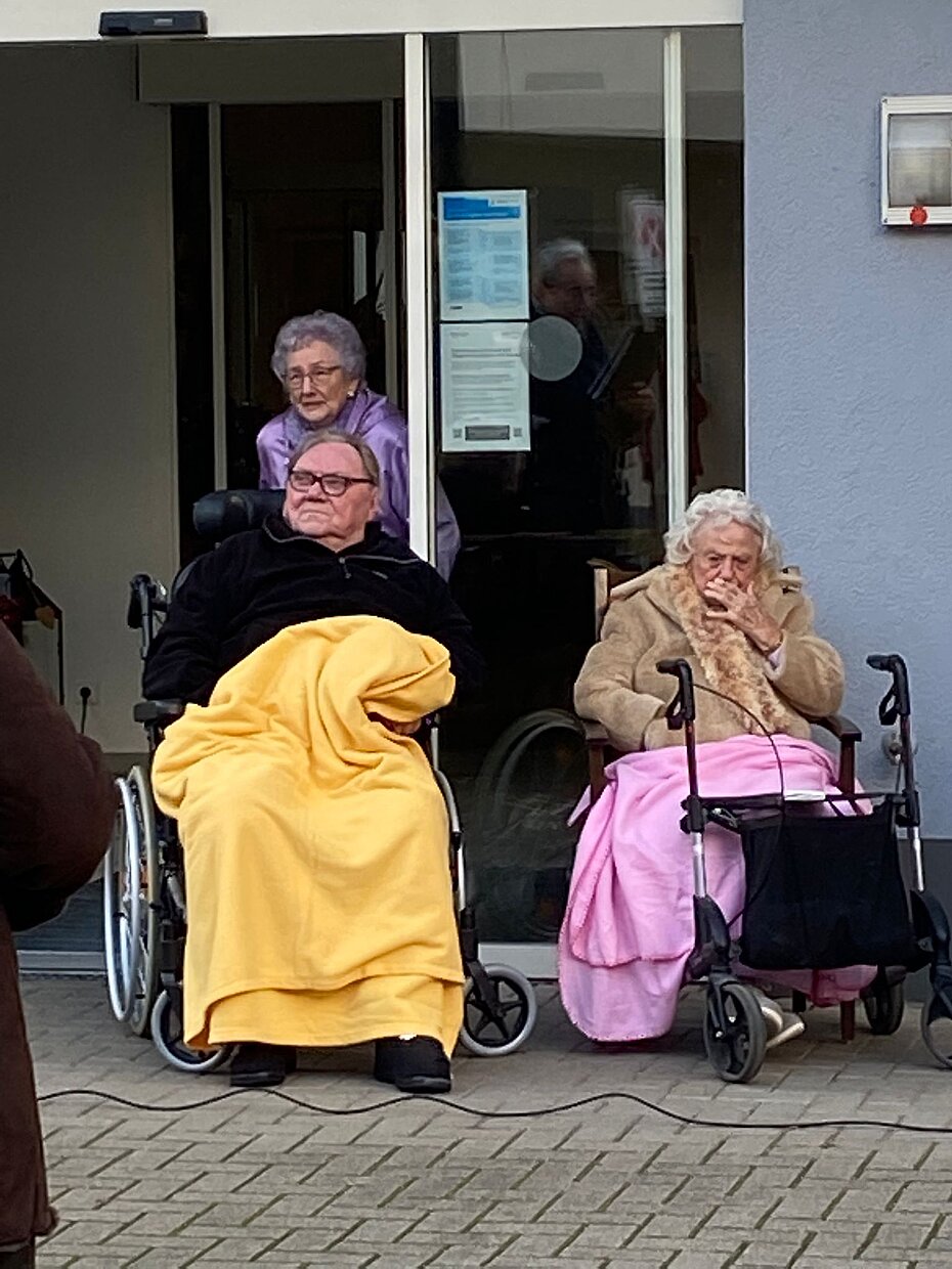 Zuhörer sitzen draußen mit Decke