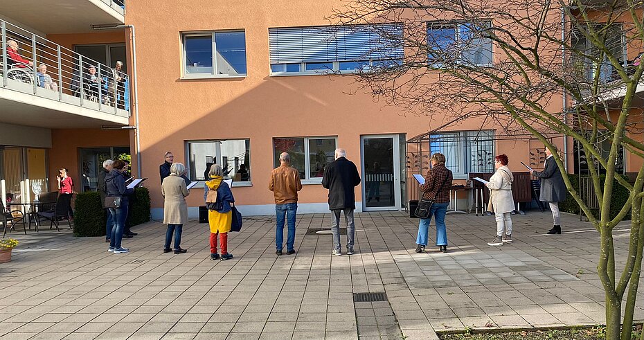 Der Chor singt im Innenhof des Wohnheims